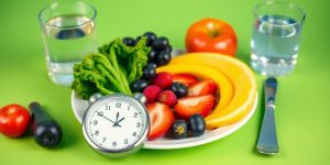 Healthy food and clock for intermittent fasting concept.